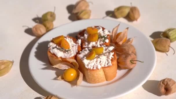 Ricotta Crostini med Physalis frukter på en vit platta — Stockvideo