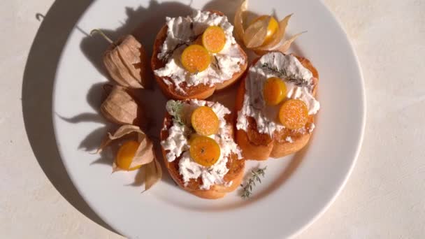Ricotta Crostini με φρούτα Physalis σε λευκό πιάτο — Αρχείο Βίντεο