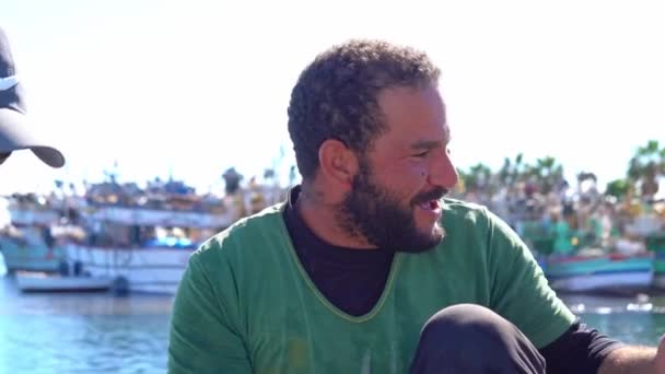 Egypt, Hurghada, 20 DECEMBER 2021: happy fisherman have a rest on the boat in a harbor — Video Stock