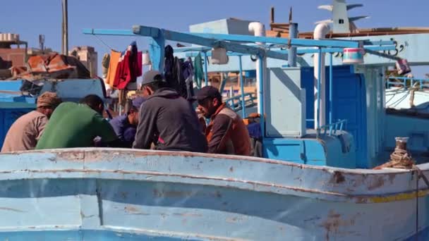 Egypt, Hurghada, 20. prosince 2021: rybáři jedí společně na lodi v přístavu — Stock video