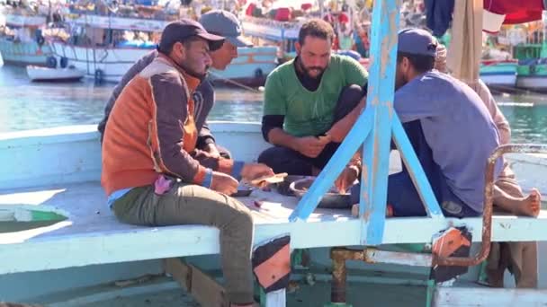 埃及，Hurghada，2021年12月20日：渔民一起吃饭，在港口的船上休息 — 图库视频影像
