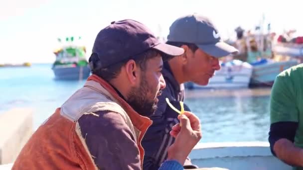 Egypt, Hurghada, 20. prosince 2021: rybáři jedí společně a odpočívají na lodi v přístavu — Stock video