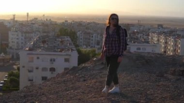 Woman looking at the sunrise ower the Hurghada city. Egypt