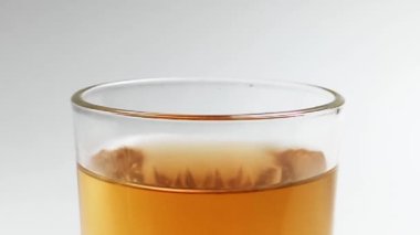 Buz küpleri bir bardak buzlu çaya dökülüyor ve su sıçratıyor.. 
