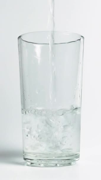 Långsam rörelse för att hälla vatten i ett genomskinligt glas — Stockvideo
