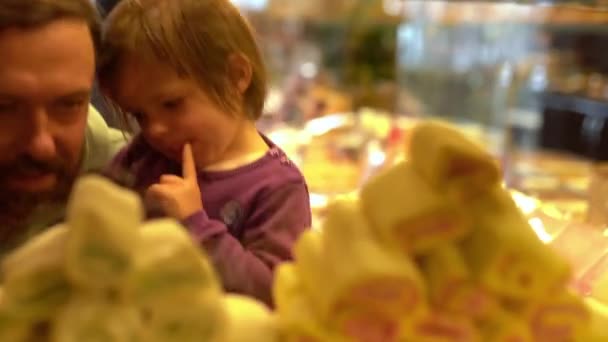 Dua gadis kecil memilih permen dengan ayah di toko permen — Stok Video