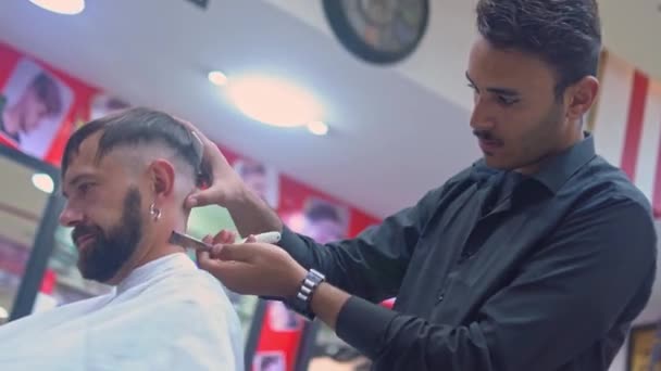 Holič stříhá muže vlasy s rovným okrajem břitva v holičství — Stock video