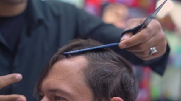 Holič stříhá muže vlasy s nůžkami zblízka — Stock video