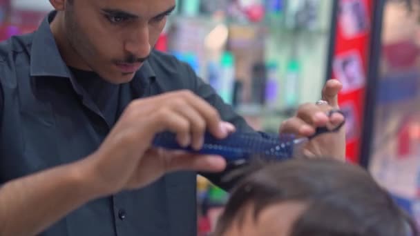 Fryzjer strzyże męskie włosy nożyczkami u fryzjera — Wideo stockowe
