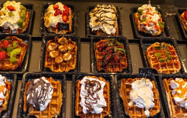 Vitrinde renkli malzemeler bulunan Belçika waffleları. Brüksel