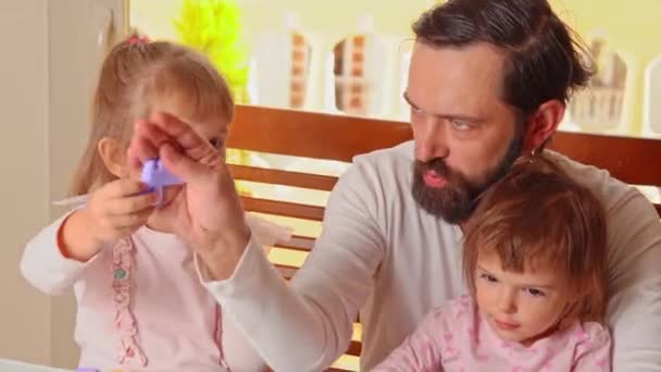 Lycklig far leker konstruktör spel med sina två döttrar hemma — Stockvideo