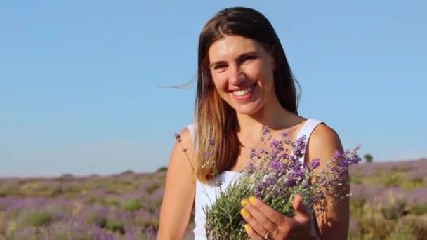 ผู้หญิงที่มีความสุขที่ยิ้มถือช่อดอกไม้ลาเวนเดอร์ — วีดีโอสต็อก