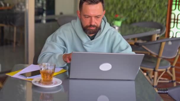 Hombre feliz con el ordenador portátil en la cafetería. — Vídeos de Stock