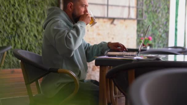 Homme buvant du thé et utilisant un ordinateur portable dans le café. — Video