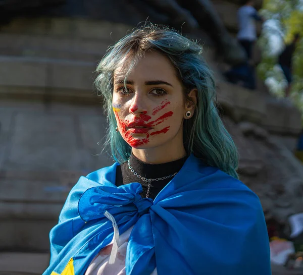 Retrato de uma mulher ativista com bandeira nacional ucraniana e traço desenhado de uma mão sangrenta no rosto — Fotografia de Stock