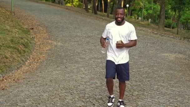 Glücklicher Junger Afrikanisch Amerikanischer Mann Park Mit Abgefülltem Wasser Der — Stockvideo