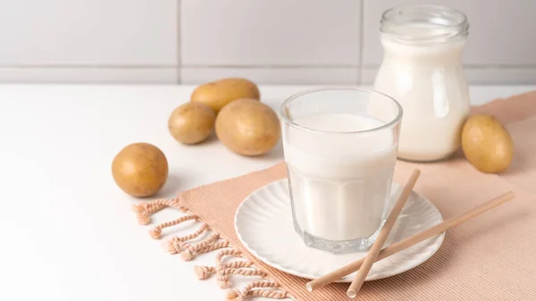 Bicchiere Trasparente Con Latte Patata Tavola Con Tuberi Patata Tendenza — Foto Stock
