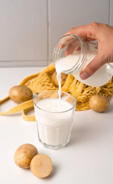 Картопляне Молоко Наливається Склянку Білому Столі Бульбами Картоплі Веганська Тенденція — стокове фото