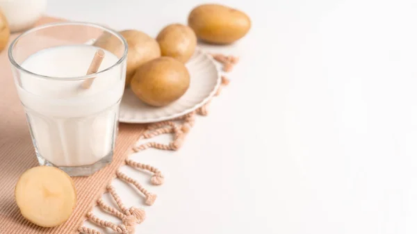 Ένα Ποτήρι Γάλα Πατάτας Στο Λευκό Τραπέζι Τους Κονδύλους Πατάτας — Φωτογραφία Αρχείου