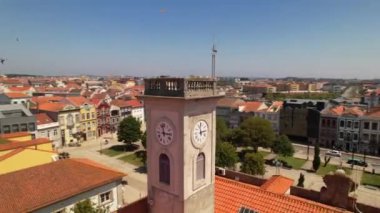 Aerial circle drone view of the bell tower in the City center of Povoa de Varzim on a bright sunny summer day, Porto region, Portugal. 