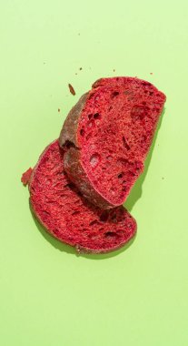 Açık yeşil arka planda iki dilim pancar çöreği. Sağlıklı ekmek kavramı