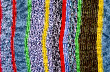 Örgü kumaş yüzeyinde farklı renkte çizgiler var. Tekstil retro halılar ya da halılar. Kumaşın dokusu çizgilerin geometrisiyle bir kombinasyondur..