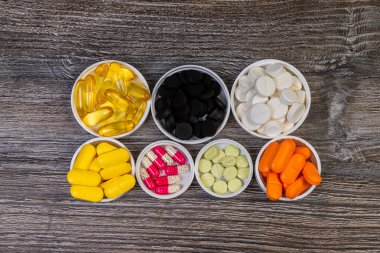 Ahşap sırtta izole edilmiş tıbbi renkli haplar.