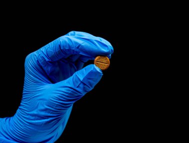 İzole edilmiş siyah arka planda tıbbi ilaçlar. Elinde yansıma, doğal organik biyolojik takviye.