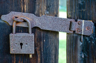 Paslı eklemli eski ahşap kapı dokusu. Kilitli kapı. Tecrit kavramı, kabul edilemezlik, engeller, gizli.