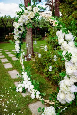 Düğün töreni. Çok güzel ve şık bir düğün kemeri, çeşitli taze çiçeklerle süslenmiş, bahçede duruyor. Düğün günü. Taze çiçek süslemeleri, şakayıklar..