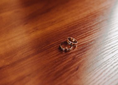 Zeminde, yerde, piyanoda, elde kontrastlı evlilik yüzükleri olan iki alyans.