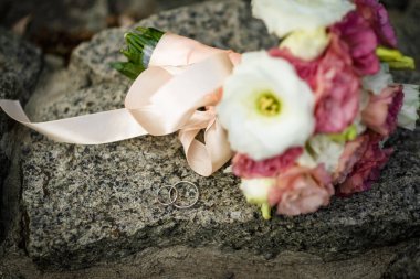 Zeminde, yerde, piyanoda, elde kontrastlı evlilik yüzükleri olan iki alyans.