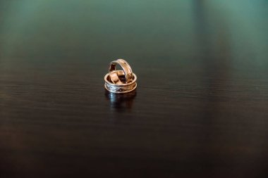 Zeminde, yerde, piyanoda, elde kontrastlı evlilik yüzükleri olan iki alyans.