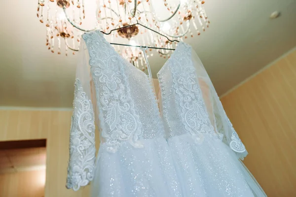 完璧なウェディング ドレスの花嫁にブルーのカーテンの部屋でハンガーに完全なスカート — ストック写真