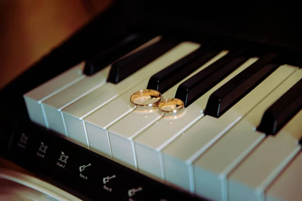 Two wedding rings on the floor with contrast wedding rings on floor, on ground, on piano, in hand