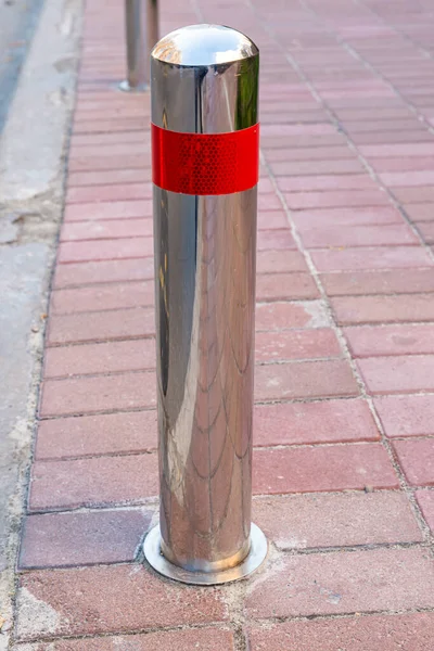 Stainless parking poles separating the sidewalk from the road. Prevention. Illegal. Control. Urban. City. No parking. Footpath