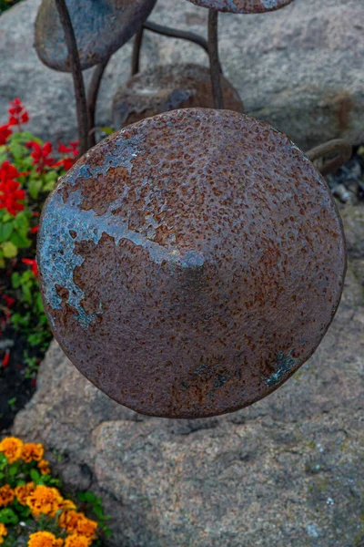 A garden sculpture of a toadstool, sculpture metal mushrooms rusted old in the park