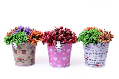 Alüminyum buz kovası kullanılmak üzere hazırlandı. Yansıması olan paslanmaz çok renkli kovalar, izole beyaz arkaplan, yeşil mavi çiçekler