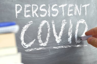 Persistent Covid concept. Hand writing on a blackboard. clipart