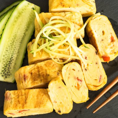 Japon omleti - tamagoyaki rulo salatalıklı yakın plan, üst manzara