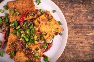 Sıcak soslu, soğanlı, susamlı ve taze soğanlı kızarmış tofu, üst manzara, kopyalama alanı.