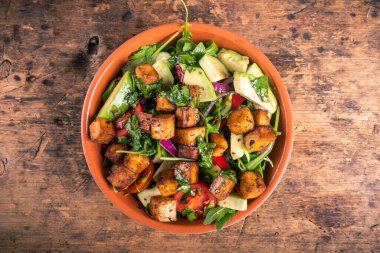 Avokadolu sebze salatası, roka ve kabın içinde kızarmış tofu, üst manzara vejetaryen mutfağı.