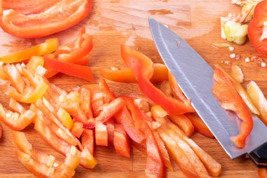 Tahtada dilimlenmiş dolma biber. Bıçakla yakın plan.