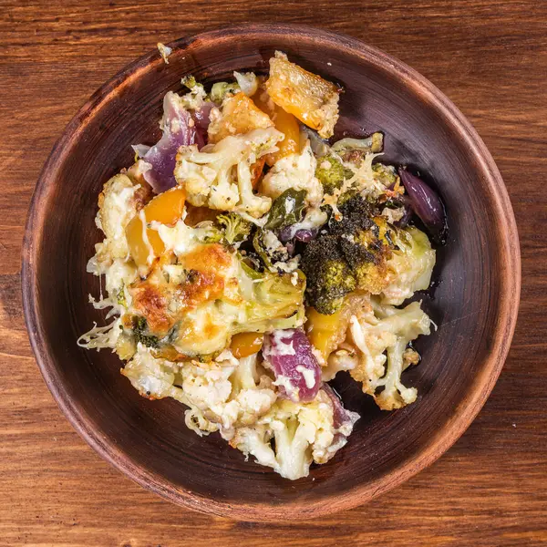 Bir tabak peynirli kabaklı fırında sebze porsiyonu, yakın plan, üst manzara.