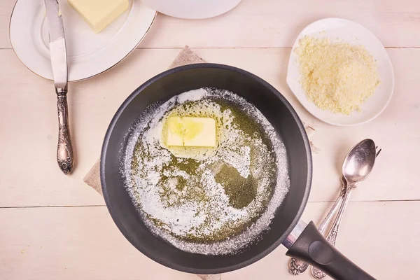 Ev yapımı Alfredo makarnası. Kızartma tavasında erimiş tereyağı ve rendelenmiş parmesan peyniri.