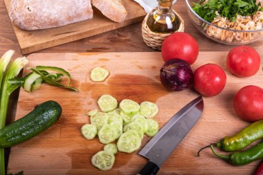 Vejetaryen panzanella salatası - domates, kırmızı soğan, acı biber, mutfak tahtasında dilimlenmiş salatalık ve bir kase ekmek kırıntısı ve maydanoz