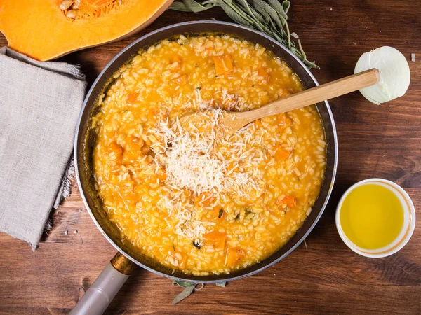 Balkabaklı risotto pişirmek. Kızartma tavasında rendelenmiş peynirli risotto. İçi malzemelerle dolu.
