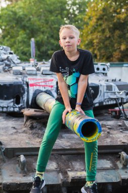 Odessa, Ukrayna - 8 Eylül 2022. Yanmış Rus askeri teçhizatıyla oynayan bir çocuk 411 sahil bataryasının parkında gösteri için getirildi.