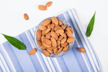 Soyulmuş bademlerle dolu mermer bir kase.