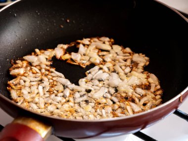 Beyaz soğanlar tavada kızarır.